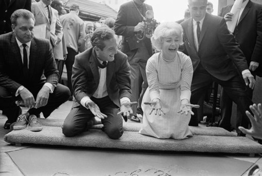 Newman and Woodward happily display cement-covered hands after leaving their prints in the forecourt of Grauman’s Chinese Theatre, May 1963. From Bettmann/Corbis.