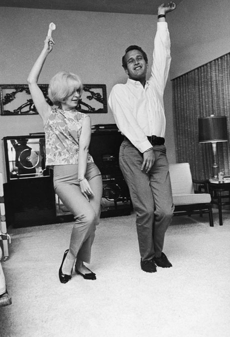 Woodward and Newman swing, 60s style, at home, 1965. By Fotos International/Getty Images.